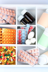 Medical pills, ampules in wooden box, close-up