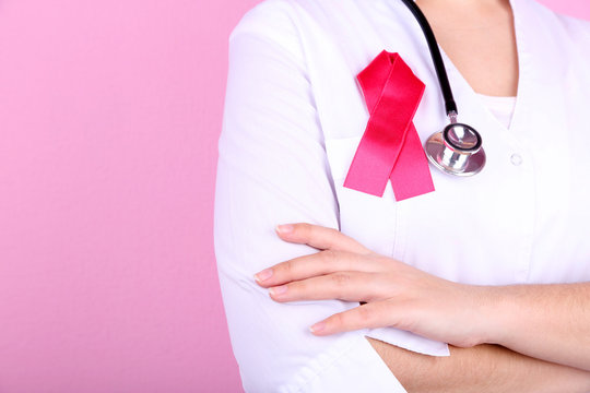 Doctor  with ribbon formed Aids symbol, close-up,