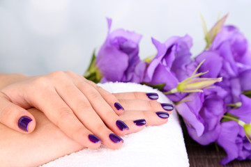 Beautiful woman hands with flowers on bright background