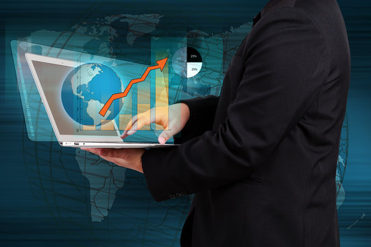 businessman holding a laptop showing business graph on virtual s