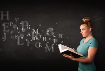Young lady reading a book with alphabet letters