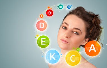 Pretty young girl with colorful vitamin icons and symbols