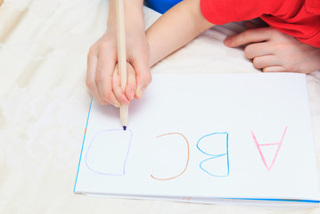 hands of mother and child writing letters