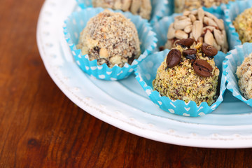 Set of chocolate candies, on plate, on wooden background