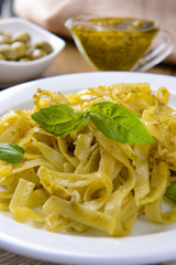 Delicious pasta with pesto on plate on table close-up