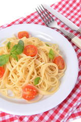 Delicious spaghetti with tomatoes on plate on table close-up