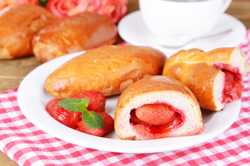 Fresh baked pasties with strawberries on plate on table