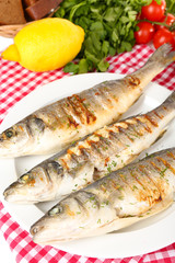Delicious grilled fish on plate on table close-up