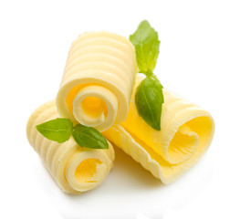 Curls of fresh butter with basil, isolated on white