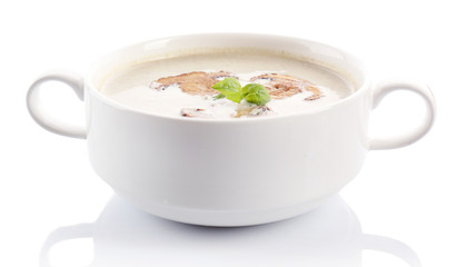 Mushroom soup in white bowl, on plate, isolated on white