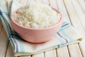 Cooked rice in bowl on wooden background