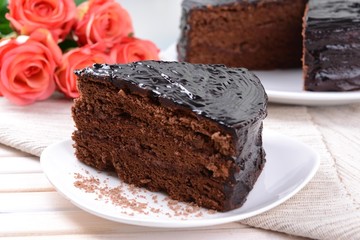Delicious chocolate cake on plate on table close-up