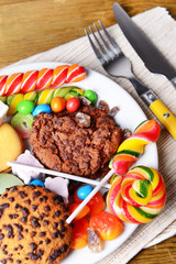 Different sweets on plate on table close-up