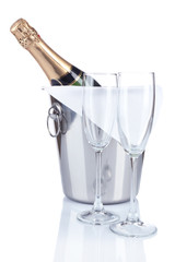 Bottle of champagne in pail and empty glasses, isolated on