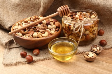 Sweet honey and different nuts on wooden table