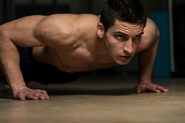 Fototapeta na wymiar Young Man Doing Press Ups In Gym