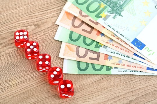Red dices and money, on wooden background