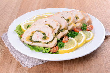 Delicious chicken roll on plate on table close-up