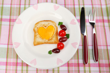 Scrambled eggs with bread on plate, on color napkin