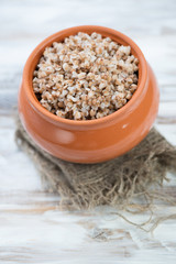 Boiled buckwheat in a ceramic pot, vertical shot