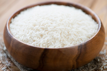 Close-up of a wooden bowl with raw basmati rice, horizontal shot