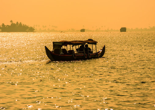 Sunset silhouette scene of a boat from the backwaters of Kerala,