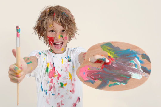 boy painting with brush and pallete