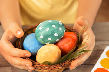 Fototapeta na wymiar Child holds Easter basket with eggs