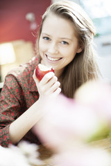 portrait closeup of a beautiful young woman eating an apple wit