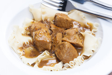 pork pieces on cumin with pasta