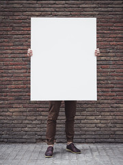 man holding blank poster