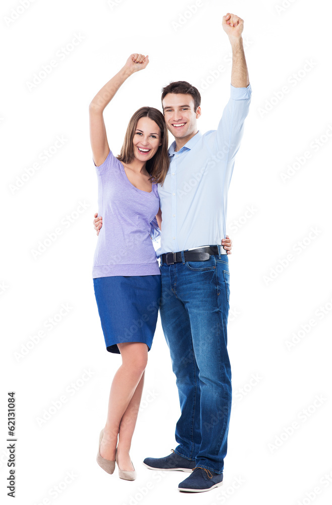 Wall mural Young couple with arms raised