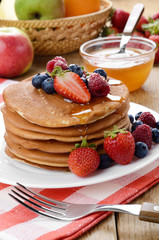 Pancakes with berries and honey closeup