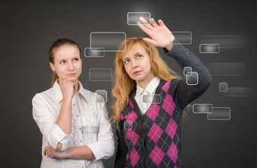 Two businesswomen near visual screen.