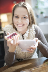 cheerful young woman at breakfast in her kitchen