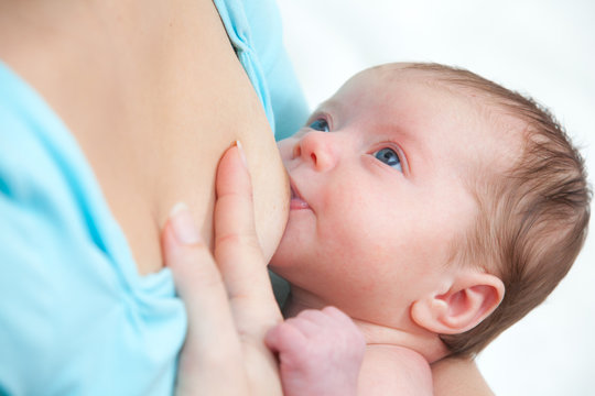 Mother breast feeding newborn baby