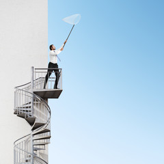 businessman with butterfly net in his hands