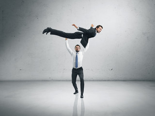 One businessman lifting the second one and helping him to fly