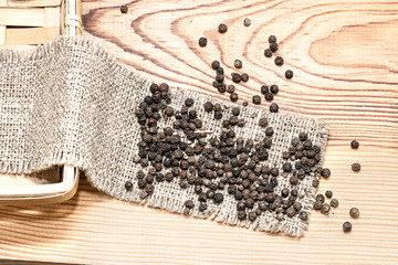 Black pepper is scattered on the wooden table