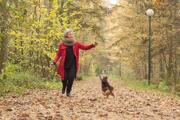 Middle aged lady is playing with her dog