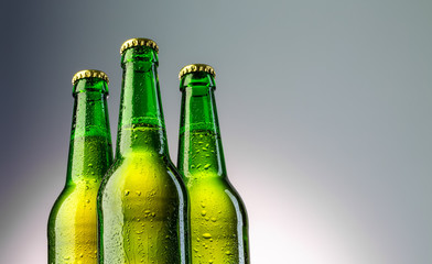 Closeup of three green beer bottles neck