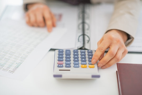 Closeup on business woman using calculator
