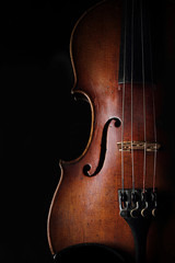 Vintage violin on dark background. Closeup view.