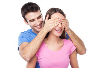 Man covering woman's eyes with his hands