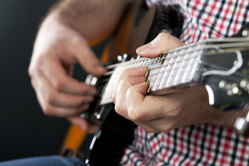 Close up on man playing guitar