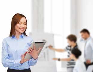 smiling woman looking at tablet pc at office