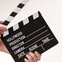 Movie flapper in woman´s hands on white background