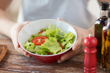 close of male hand holding a bowl with salad