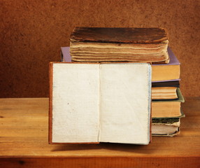 Books stack and opened book on wooden table