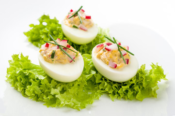 Stuffed eggs on lettuce with chives garnish